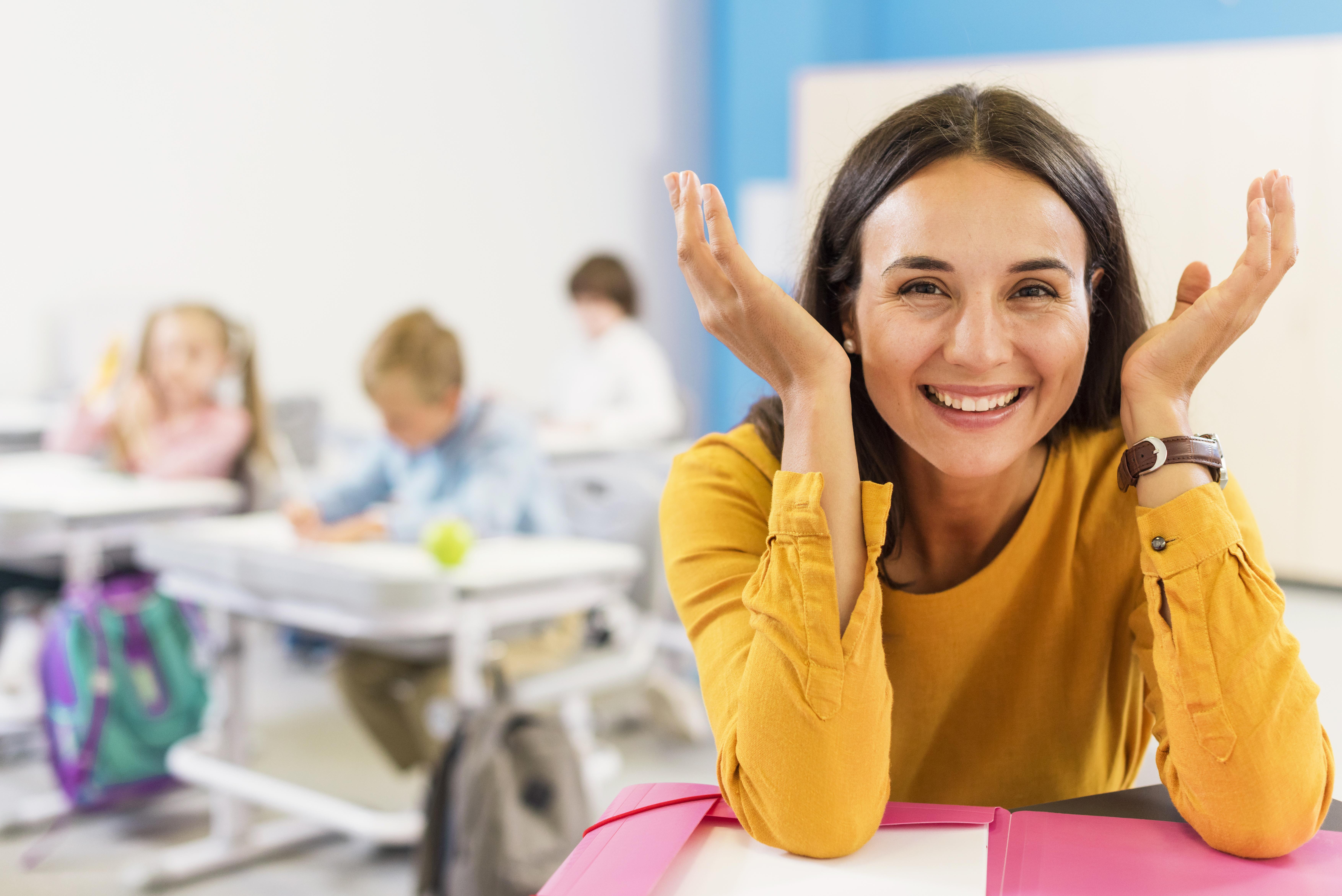 happy-teacher-sitting-her-desk
